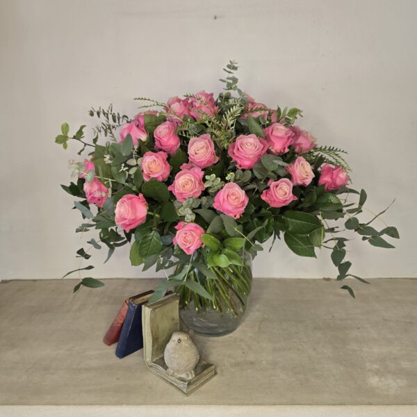 Bouquet of pink roses with eucalyptus and greenery in a glass vase